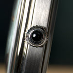 Smiths x AV86 Raqeeqa — the dark cabochon at the crown, seen head-on against the brushed case flank