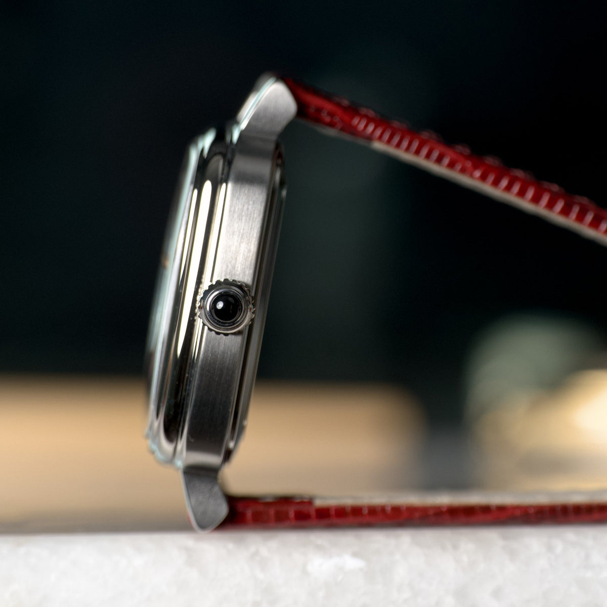 Smiths x AV86 Raqeeqa — case profile with the crown cabochon and burgundy lizard-grain leather strap